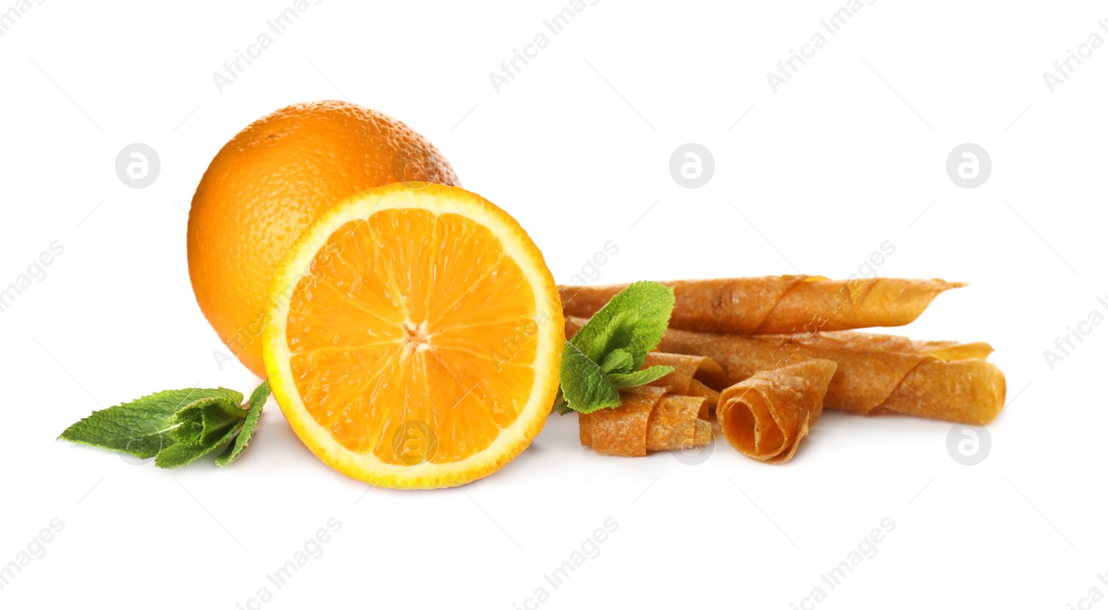 Photo of Delicious fruit leather rolls, mint and oranges on white background