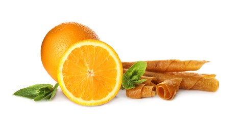 Photo of Delicious fruit leather rolls, mint and oranges on white background