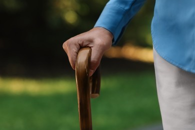 Senior woman with walking cane outdoors, closeup