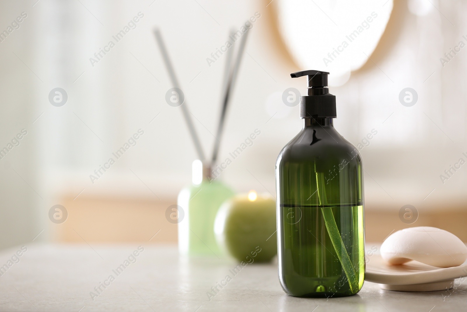 Photo of Green soap dispenser on white countertop in bathroom. Space for text