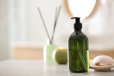 Photo of Green soap dispenser on white countertop in bathroom. Space for text