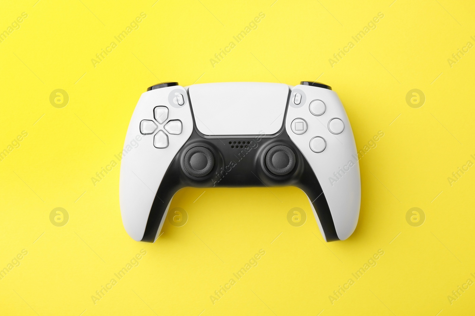 Photo of Wireless game controller on yellow background, top view