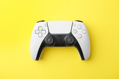 Wireless game controller on yellow background, top view