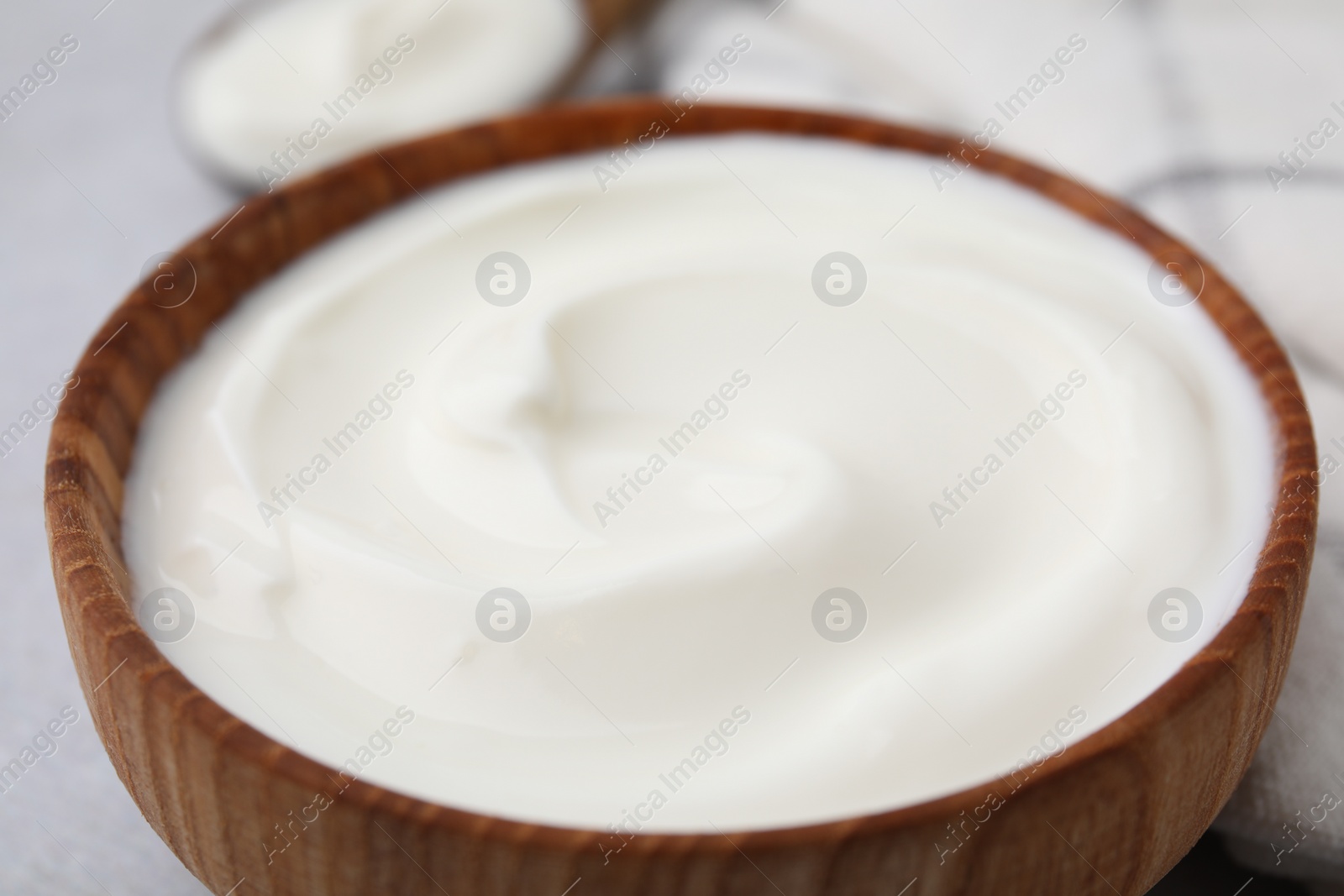 Photo of Delicious natural yogurt in bowl on table, closeup