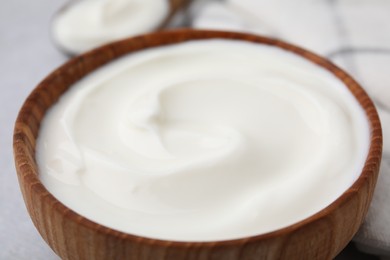 Delicious natural yogurt in bowl on table, closeup