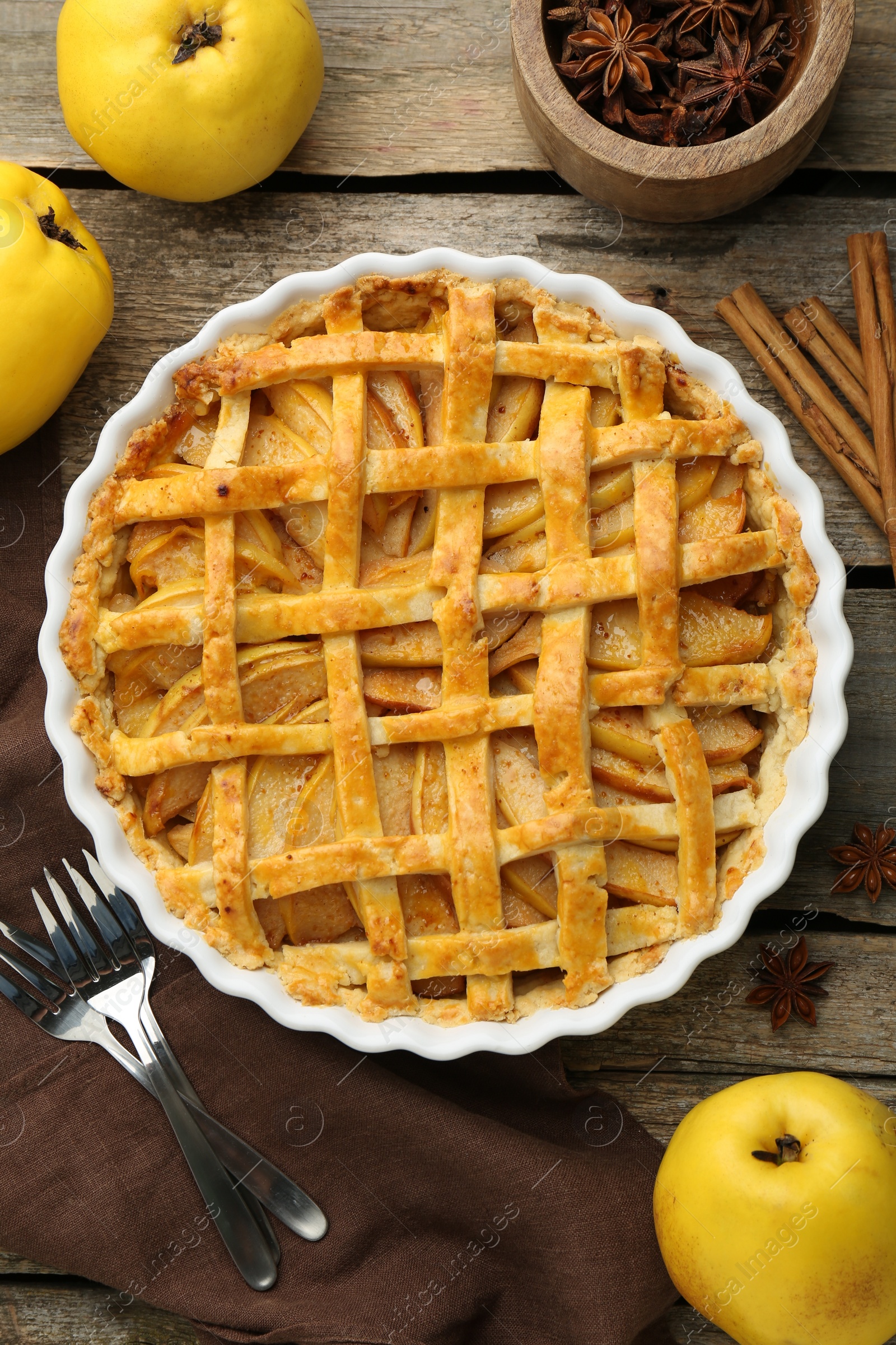 Photo of Tasty homemade quince pie served on wooden table, flat lay