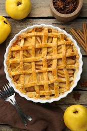 Tasty homemade quince pie served on wooden table, flat lay