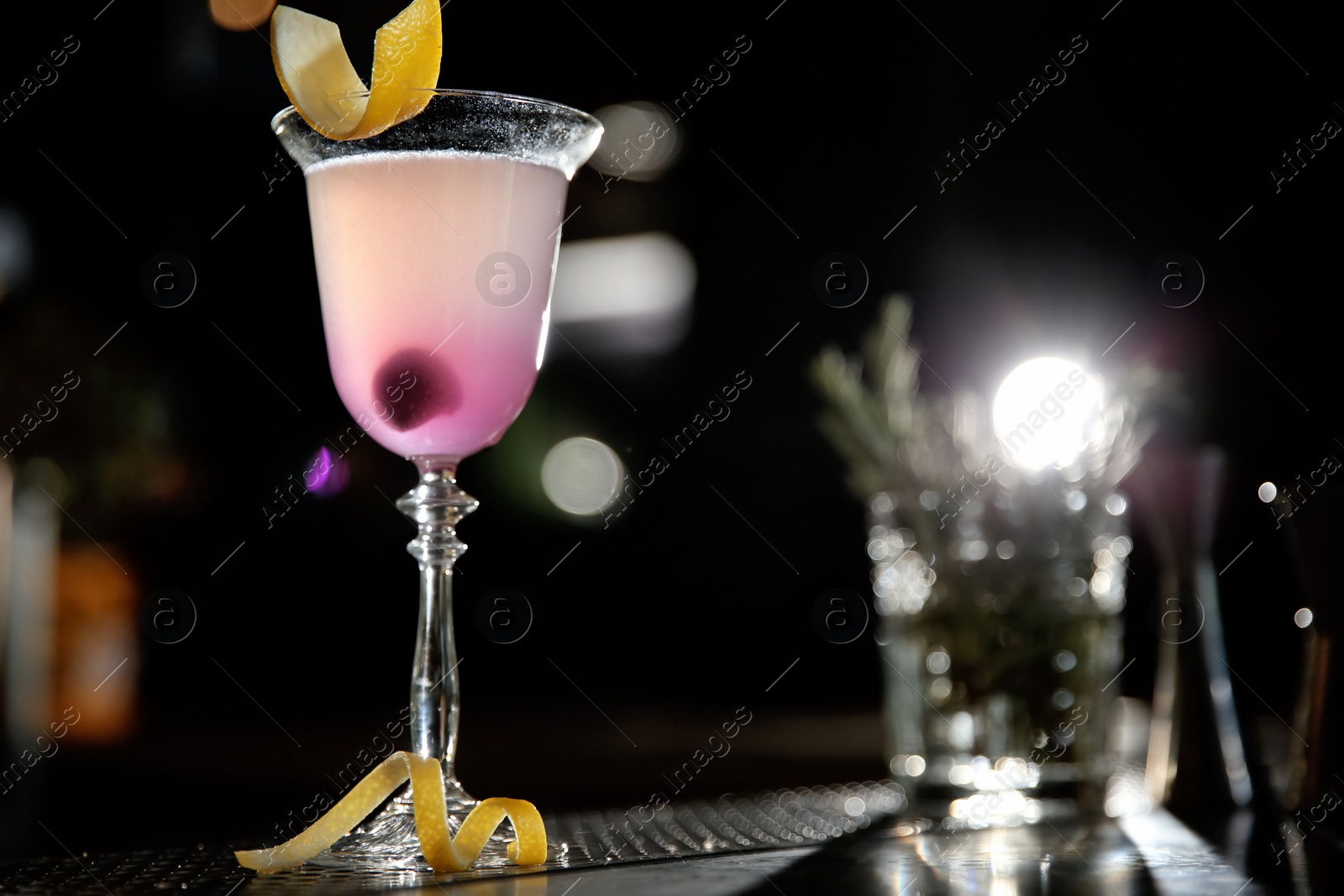 Photo of Glass of cosmopolitan martini cocktail on bar counter. Space for text