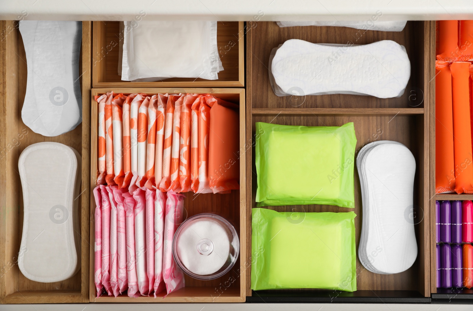 Photo of Storage of different feminine hygiene products in wooden drawer, top view