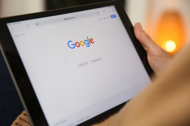 Photo of MYKOLAIV, UKRAINE - OCTOBER 31, 2020: Woman using Google search engine on tablet indoors, closeup