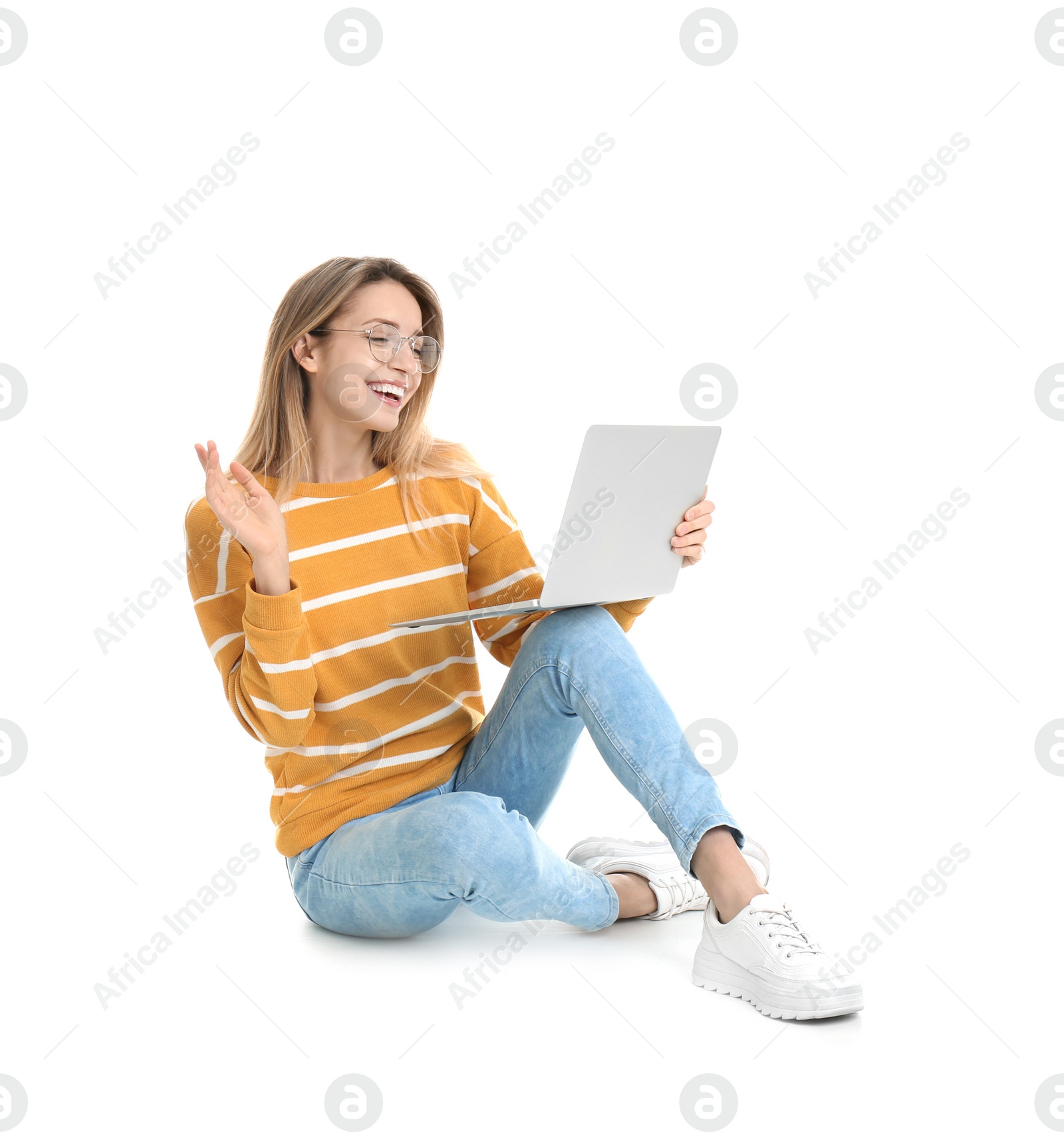 Photo of Young woman in casual outfit with laptop sitting on white background