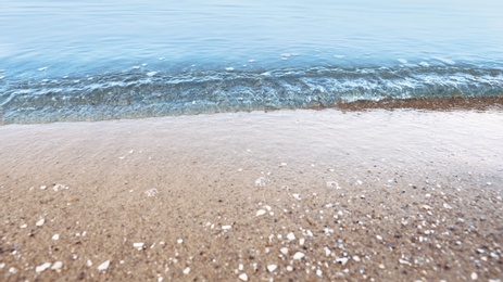 Photo of View of sea water and beach sand on sunny summer day