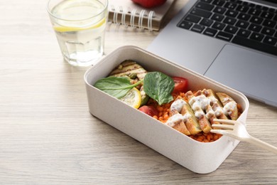 Photo of Healthy products high in vegetable fats near laptop on wooden table, closeup. Space for text