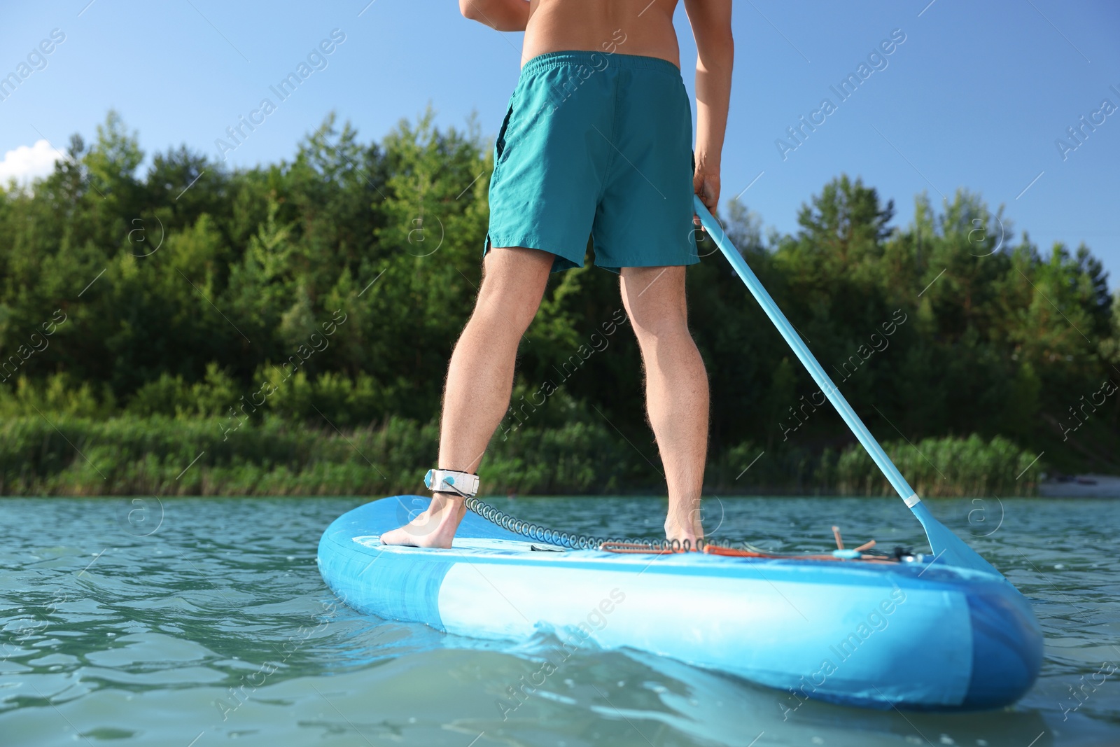 Photo of Man paddle boarding on SUP board in river, closeup