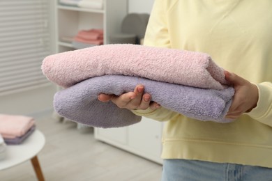 Photo of Woman holding new towels in home textiles store, closeup
