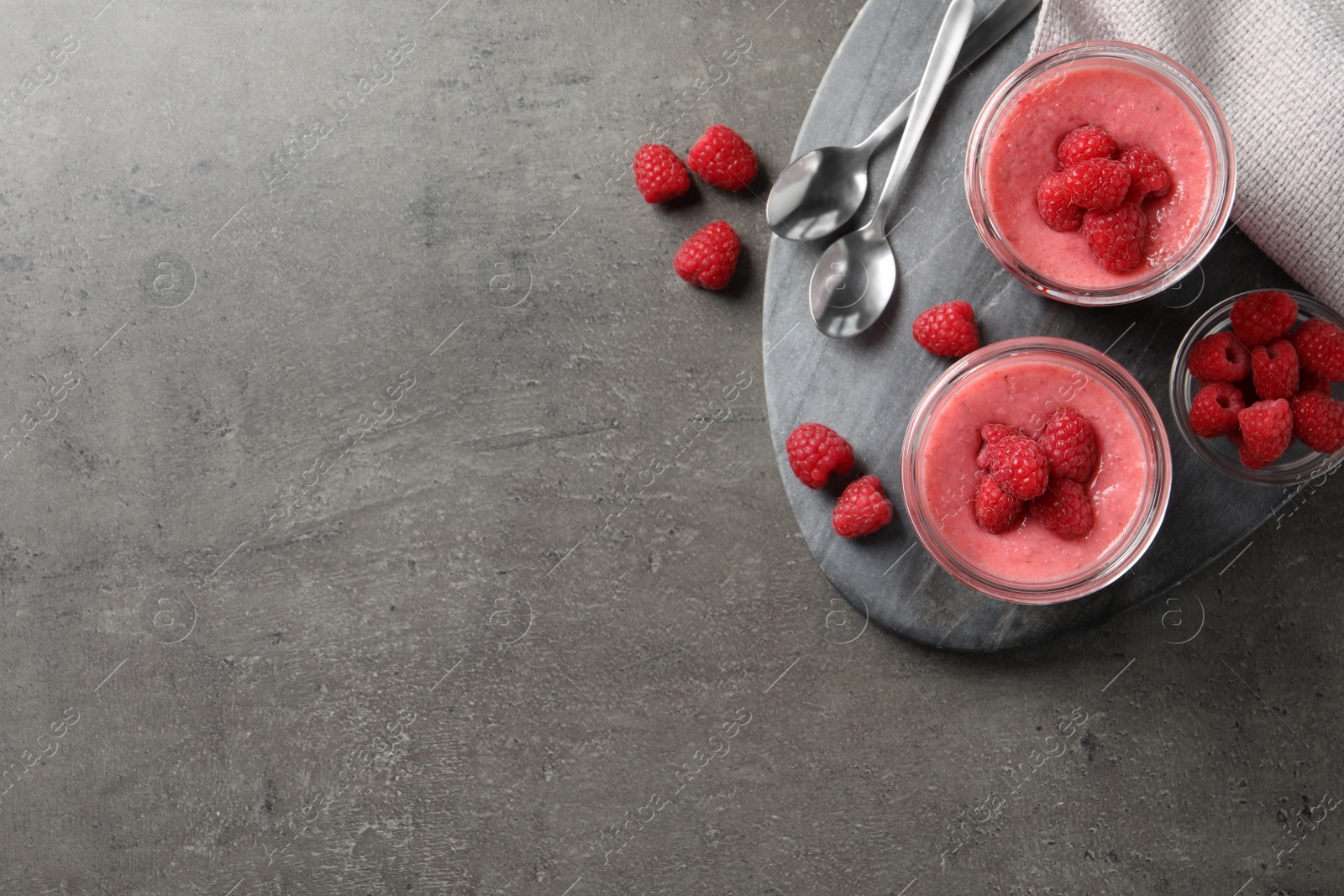 Photo of Delicious raspberry mousse served on grey table, flat lay. Space for text