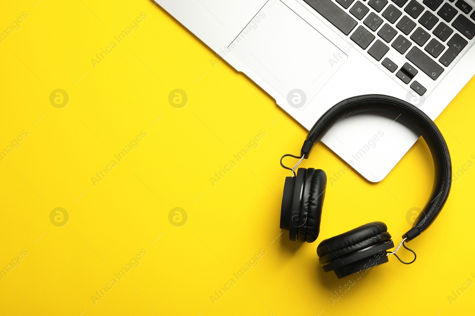 Photo of Modern headphones and laptop on color background, flat lay. Space for text