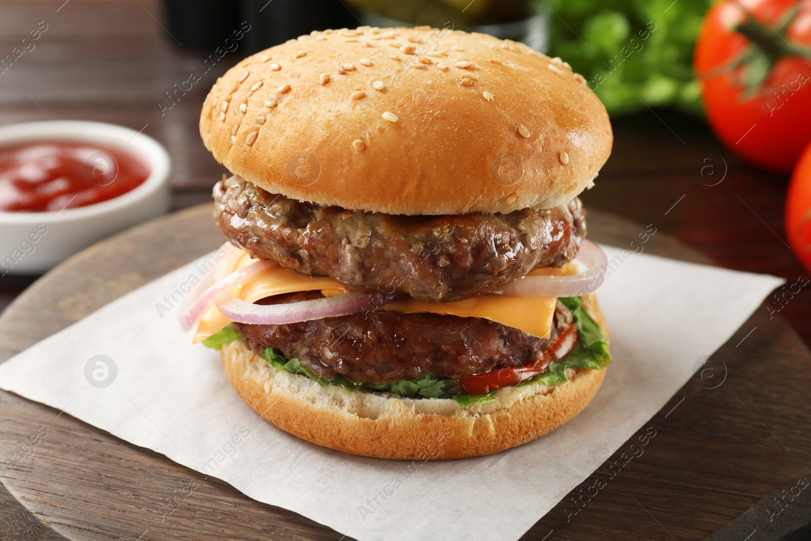 Photo of Tasty hamburger with patties, cheese and vegetables on wooden board, closeup