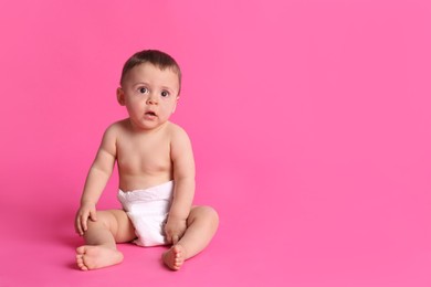 Cute baby in dry soft diaper sitting on pink background. Space for text