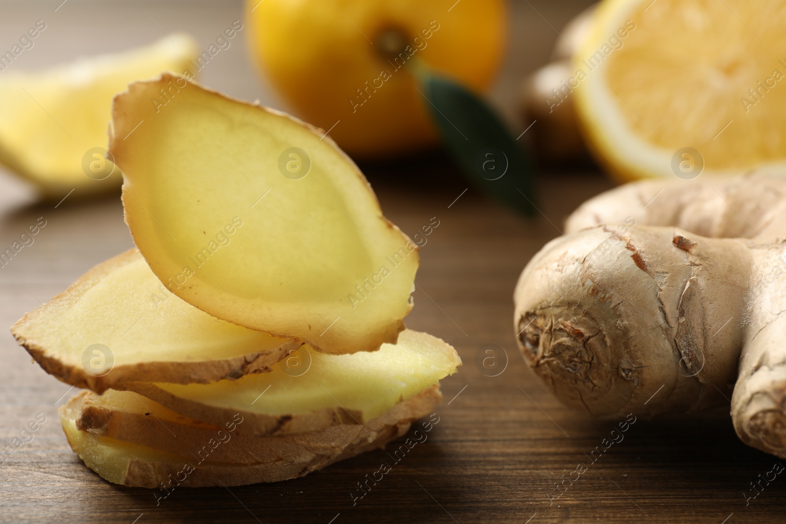 Photo of Cut ginger and lemon on wooden table, closeup