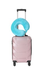 Photo of Light blue travel pillow on suitcase against white background