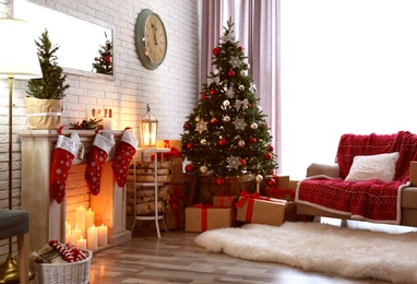 Photo of Stylish interior with beautiful Christmas tree and decorative fireplace