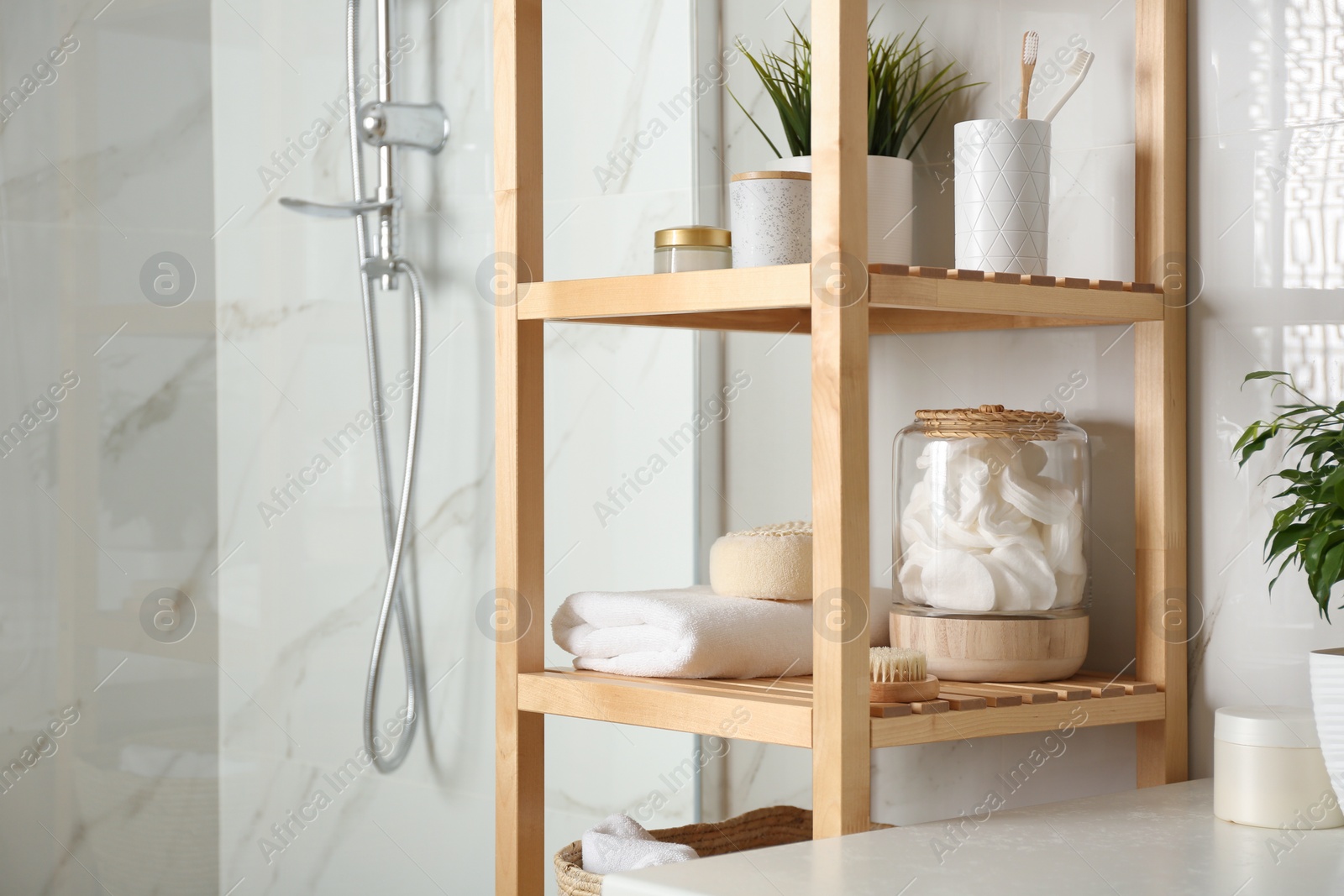 Photo of Shelving unit with toiletries in bathroom interior