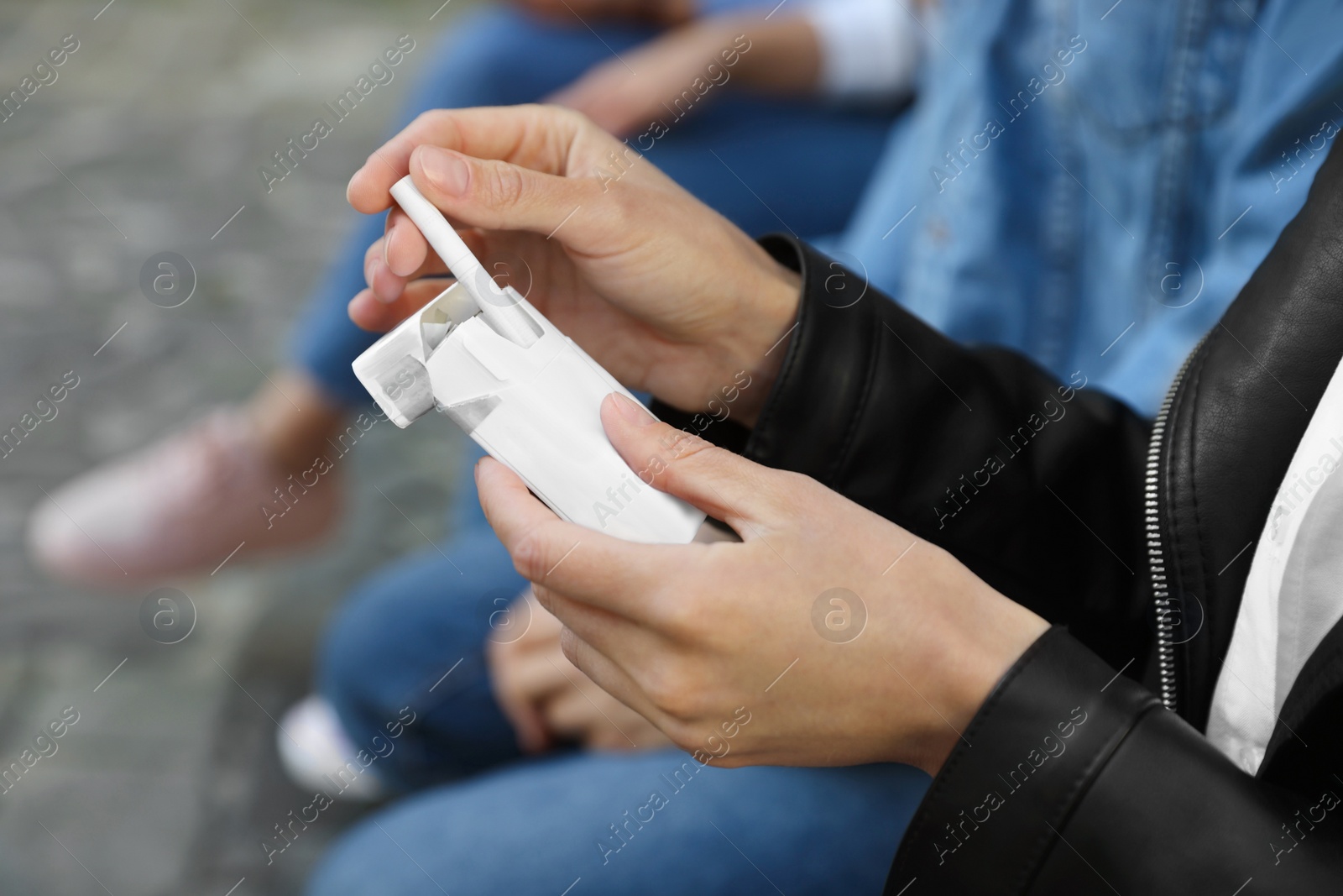 Photo of Woman taking cigarette out of pack outdoors, closeup