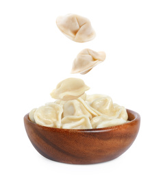 Many tasty dumplings falling into bowl on white background