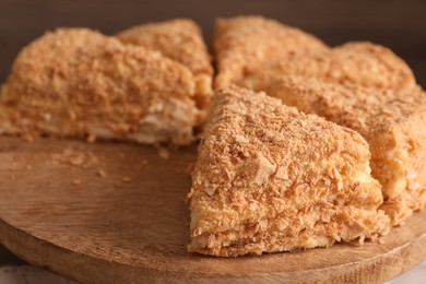 Photo of Pieces of delicious Napoleon cake on board, closeup