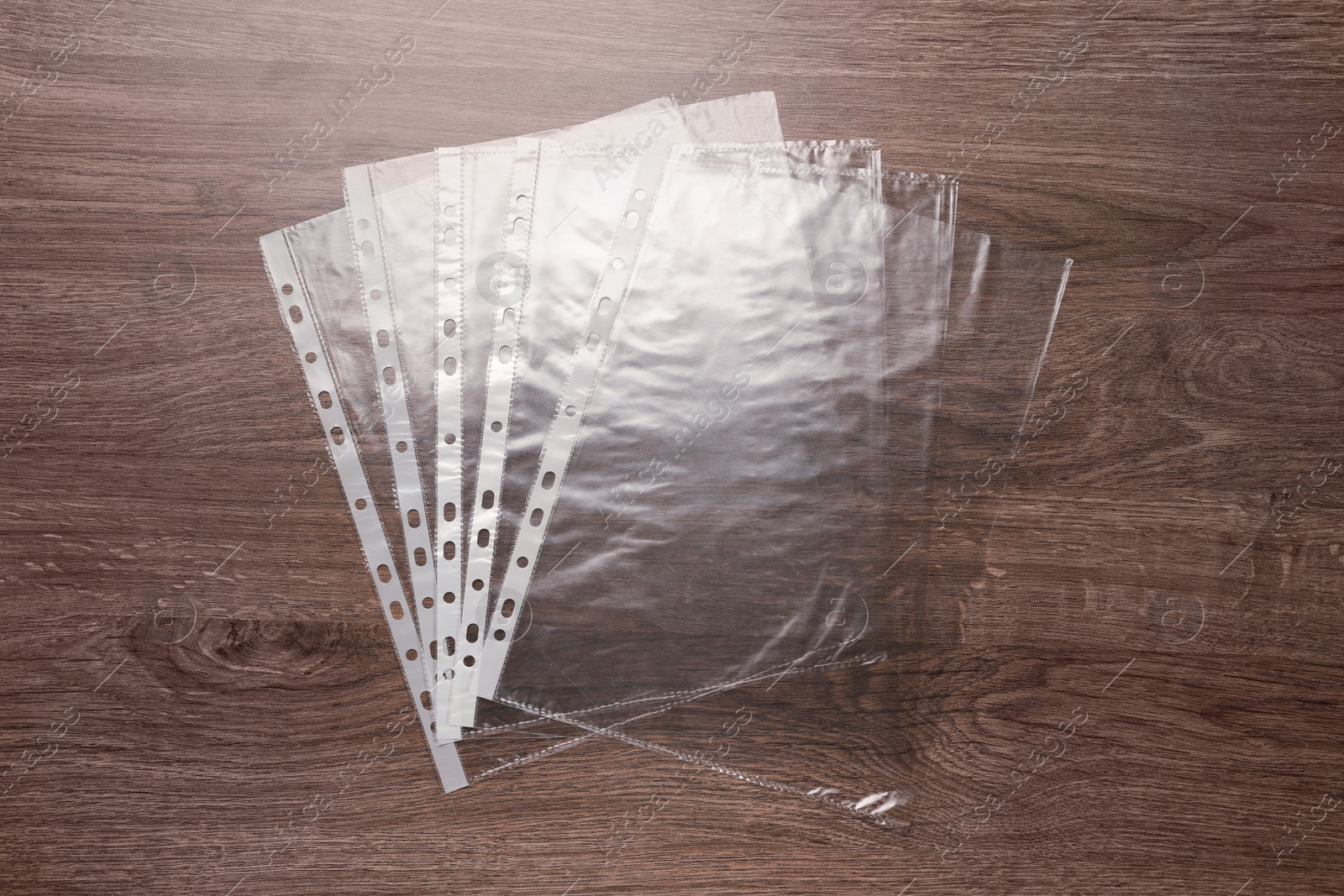 Photo of Punched pockets on wooden table, flat lay