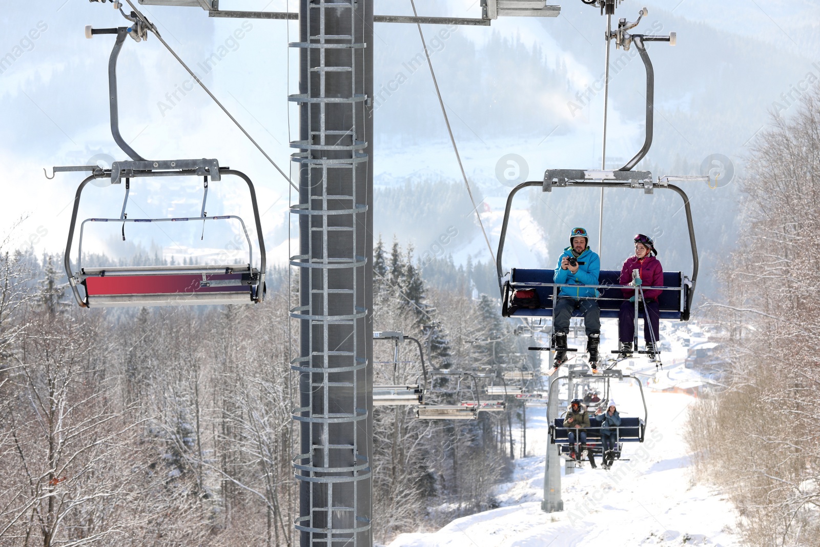 Photo of People using chairlift at mountain ski resort. Winter vacation