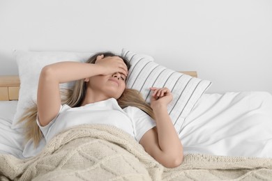 Photo of Sleepless young woman in bed at home