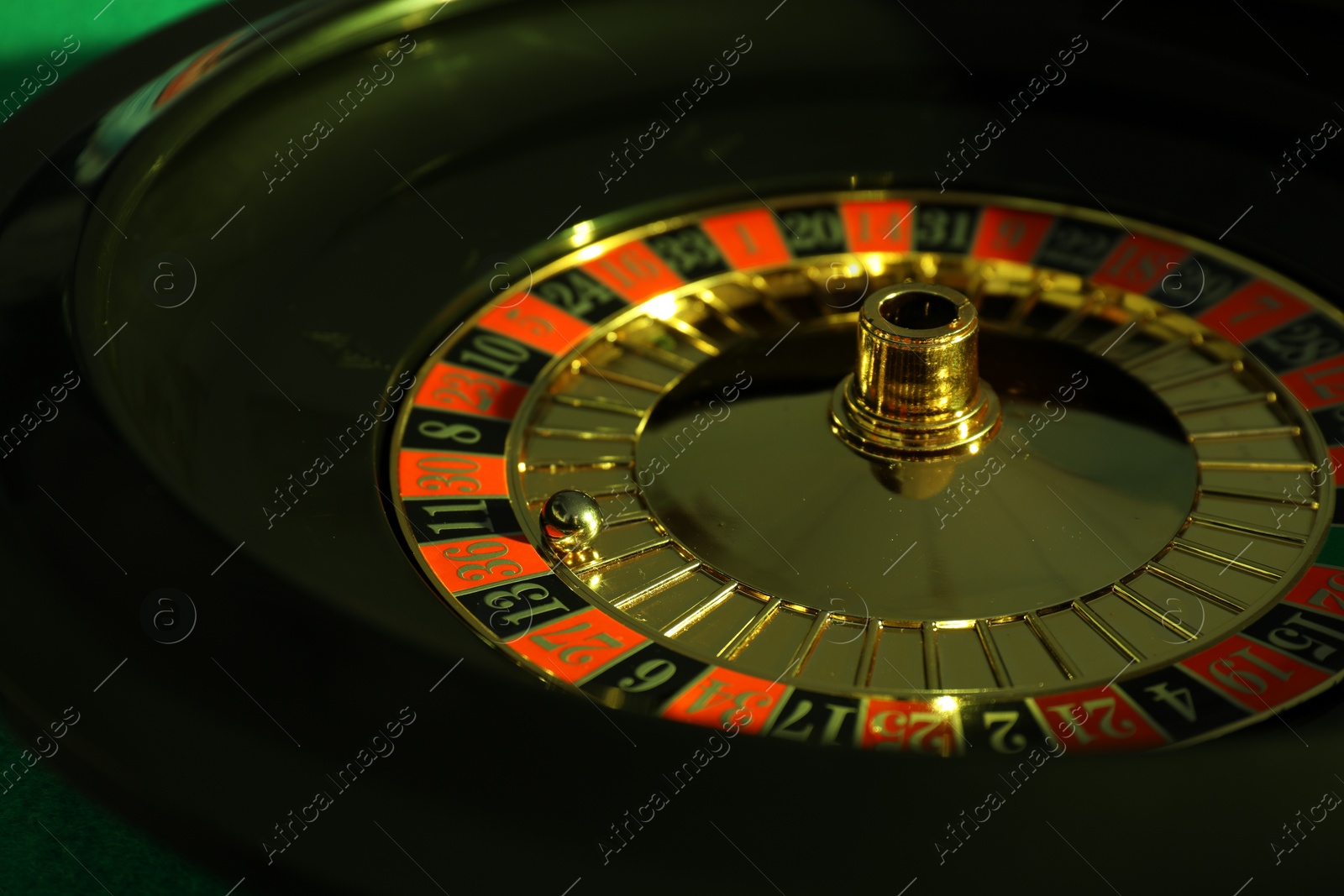 Photo of Roulette wheel with ball, closeup. Casino game