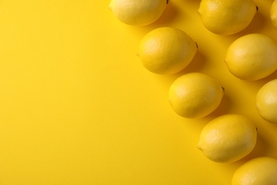 Photo of Ripe lemon fruits on yellow background, flat lay. Space for text
