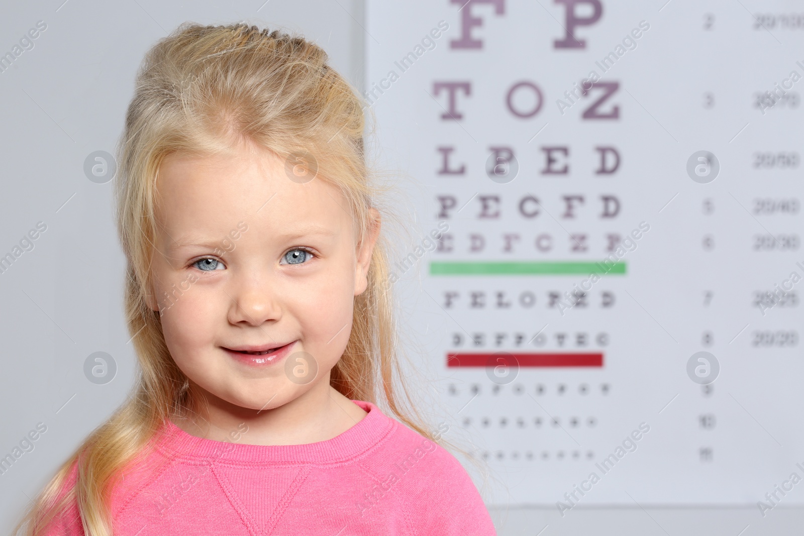 Photo of Portrait of cute little girl visiting children's doctor, space for text. Eye examination