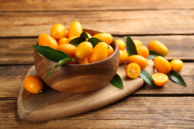 Fresh ripe kumquats with leaves on wooden table