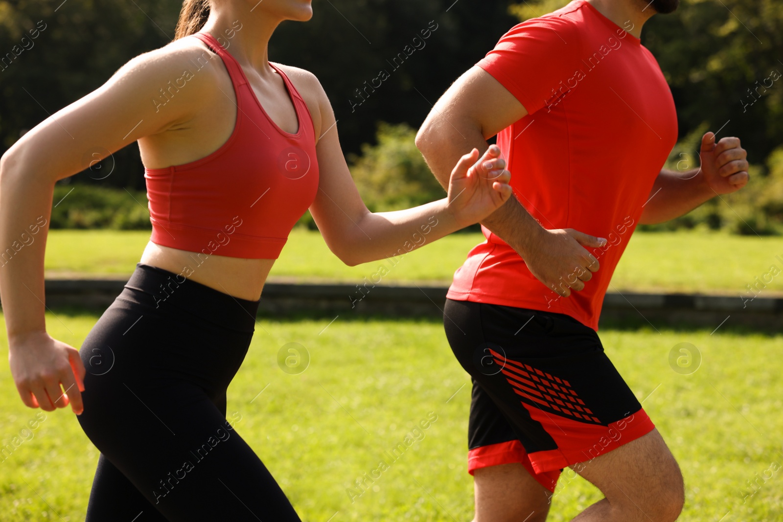 Photo of Healthy lifestyle. Couple running in park on sunny day, closeup