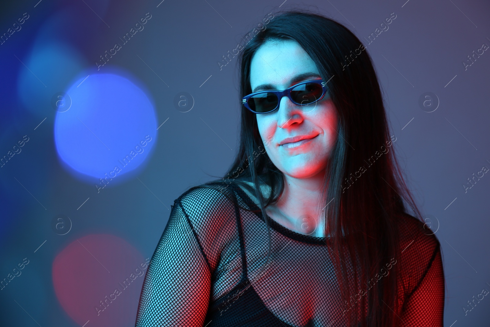 Photo of Portrait of beautiful young woman with sunglasses on color background