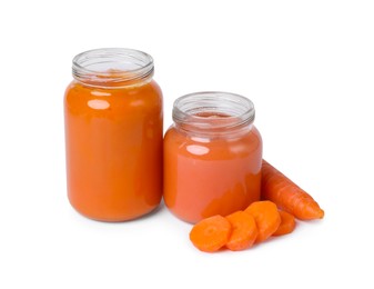 Photo of Jars of healthy baby food and carrot slices on white background