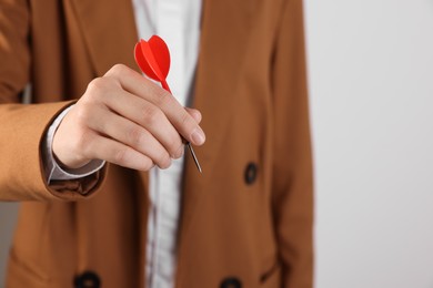 Photo of Businesswoman holding red dart on white background, closeup