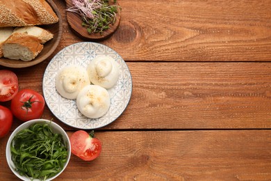 Photo of Delicious burrata cheese on wooden table, flat lay. Space for text