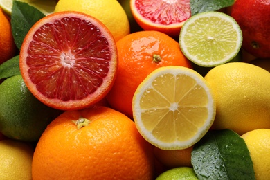 Photo of Different ripe citrus fruits as background, closeup