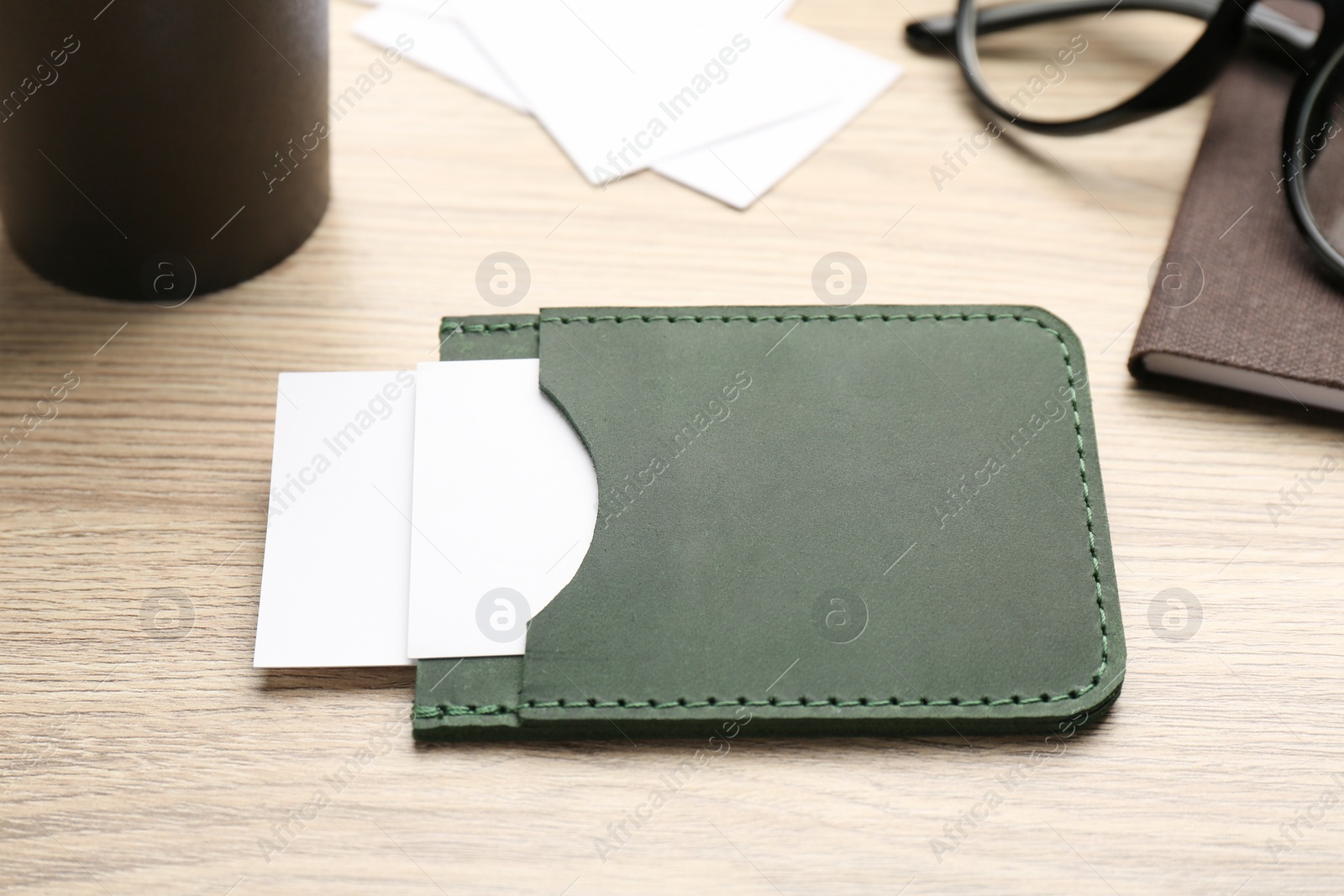 Photo of Leather business card holder with cards on wooden table