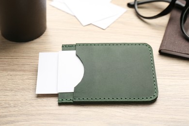 Leather business card holder with cards on wooden table