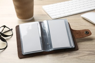 Photo of Leather business card holder with blank cards on wooden table