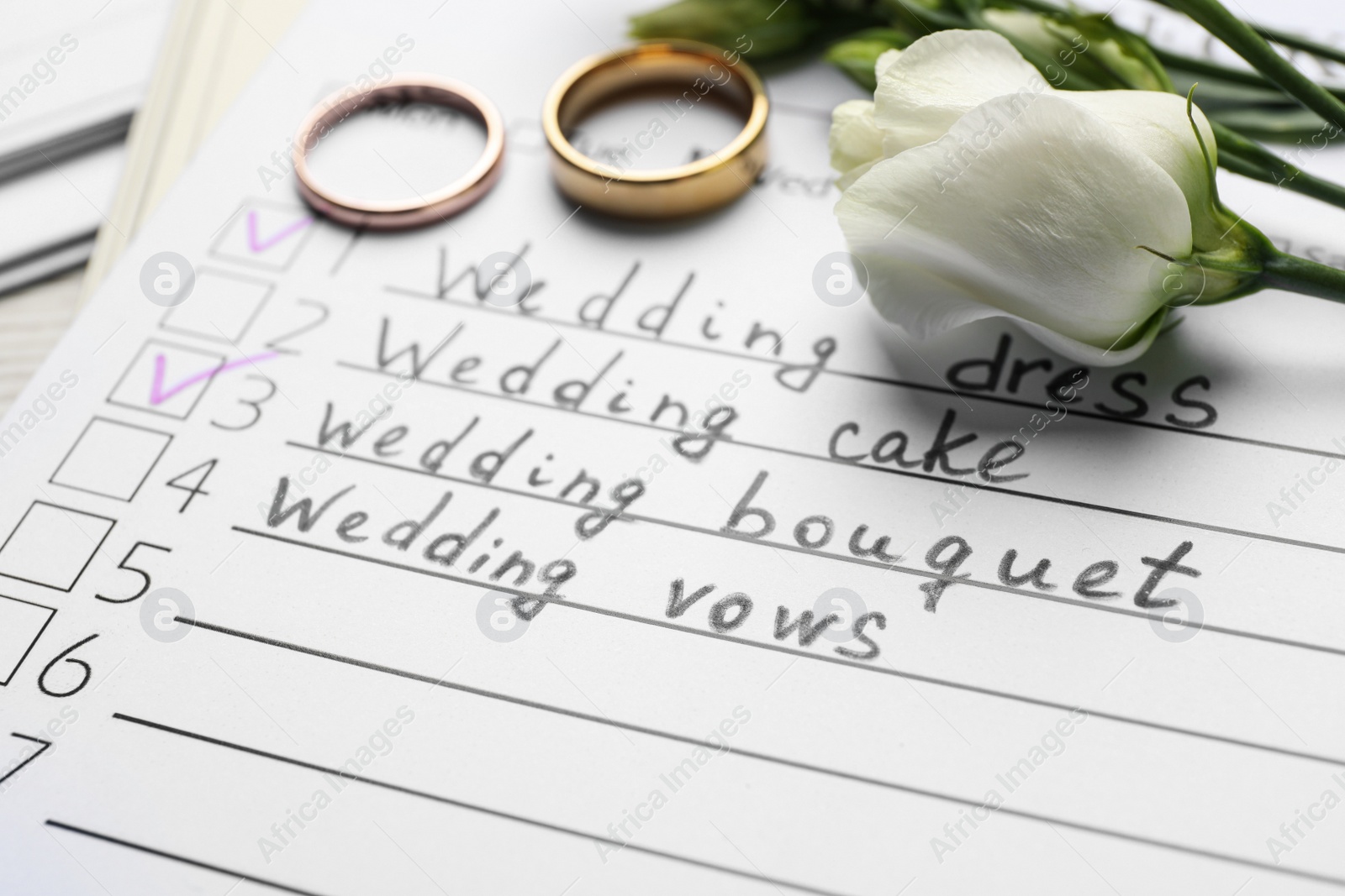 Photo of Wedding Checklist, flowers and rings, closeup view