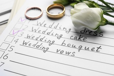 Photo of Wedding Checklist, flowers and rings, closeup view