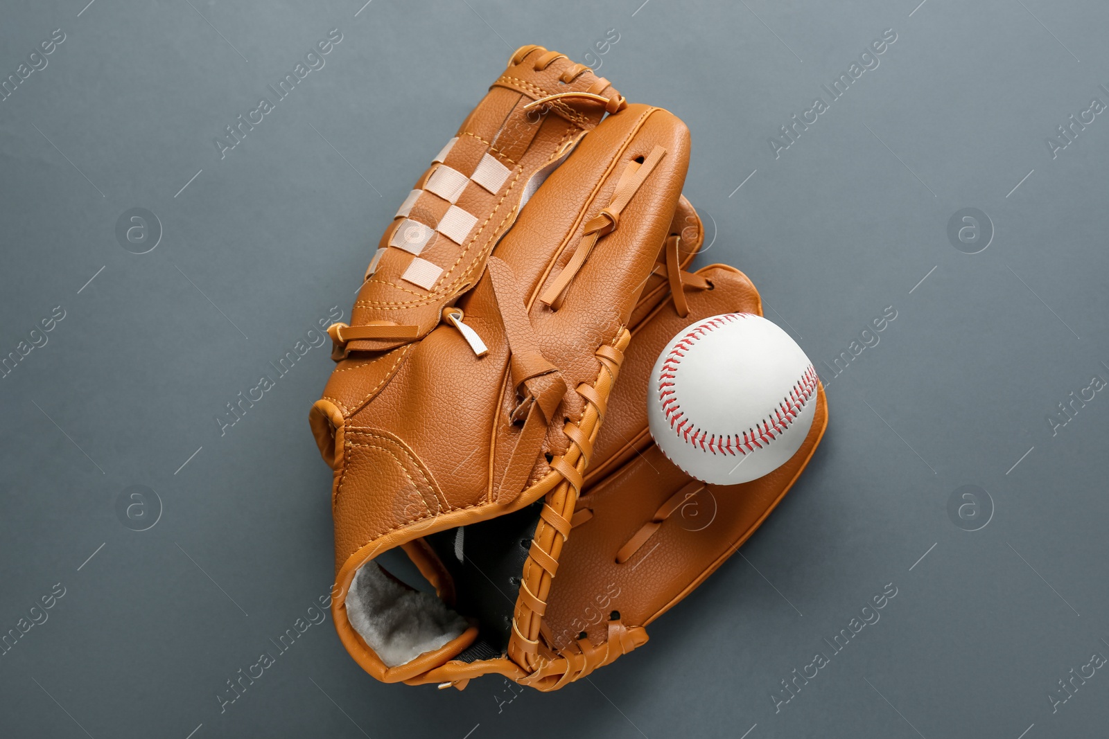 Photo of Catcher's mitt and baseball ball on dark background, top view. Sports game