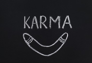 Photo of Drawn boomerang and word Karma written on blackboard